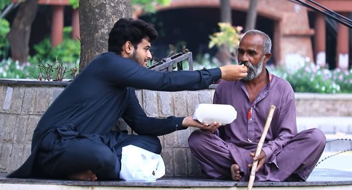 Ilutrasi: seorang pria yang sedang memberi makanan kepada pengemis salah satu contoh pria dengan akhlak baik (good attitude)