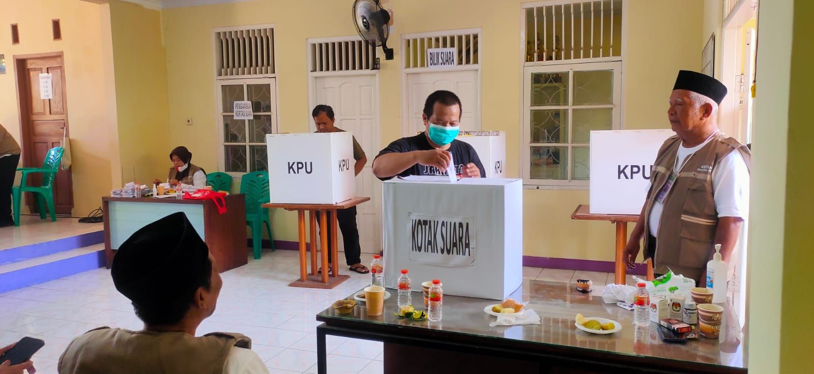 Seorang warga disaksikan panitia memasukkan surat suara ke kotak suara dalam pemilihan Ketua RW 7 Kelurahan Kelapa Dua, Kecamatan Kelapa Dua, Kabupaten Tangerang Banten, Minggu 18 Desember 2022.