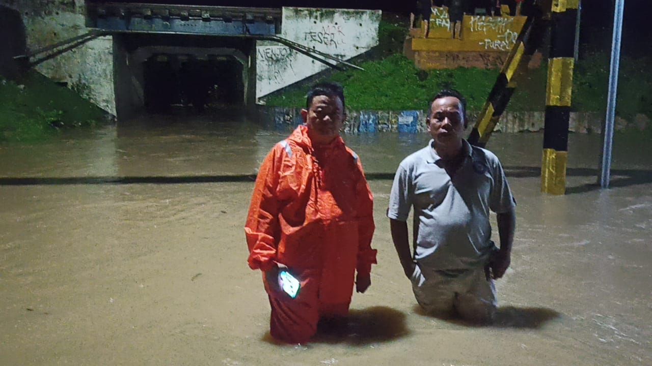 Camat Mundu Anwar Sadat (jas hujan) memperlihatkan titik banjir akibat hujan deras dengan intensitas tinggi yang melanda wilayah Cirebon dan sekitarnya pada Rabu, 21 Desember 2022. Akibatnya, sejumlah titik permukiman warga terdampak banjir. 