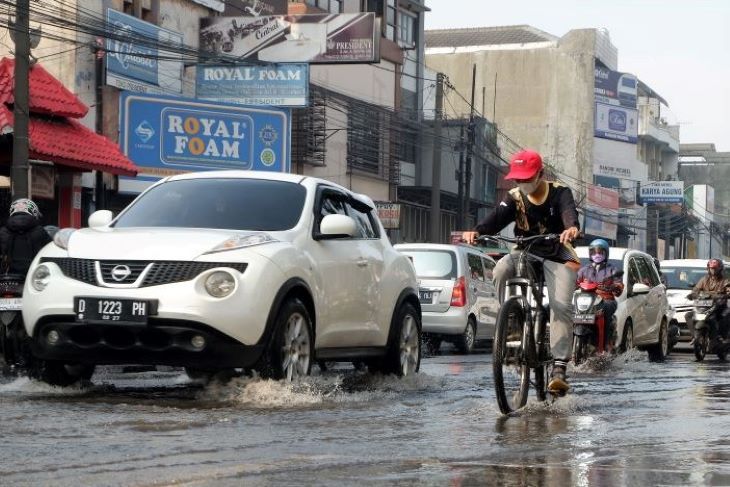 Pesepeda melewati genangan air di Jalan Jenderal Ahmad Yani Cicadas Kota Bandung.