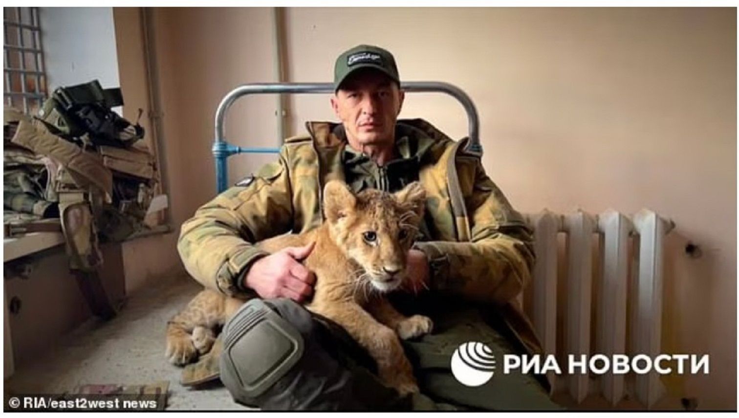 Stanislav 'Spaniard' Orlov, 41, pemimpin kelompok, dengan maskot utama mereka, anak singa yang mereka 'temukan' di Mariupol./  