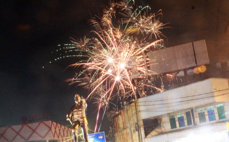 Kembang api menyala dengan latar patung pahlawan Kapten Tubagus Muslihat saat malam perayaan tahun baru 2023 di Kota Bogor, Jawa Barat, Minggu, 1 Januari 2023.