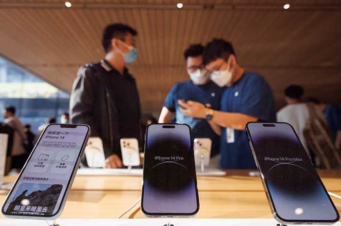 Seorang pelanggan berbicara dengan asisten penjualan di toko Apple saat model iPhone 14 baru Apple Inc mulai dijual di Beijing, Cina, 16 September 2022. 