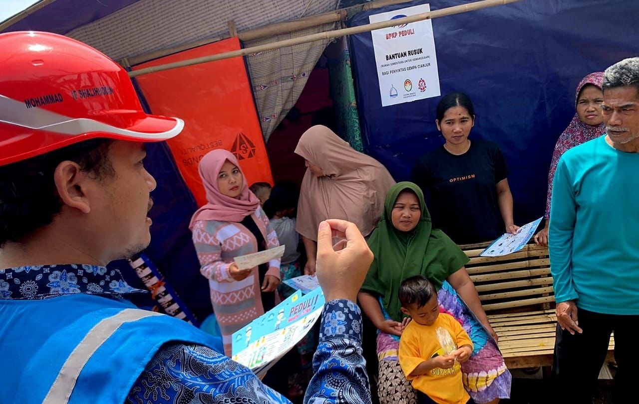 Petugas PLN saat berkomunikasi dengan warga korban gempa Cianjur