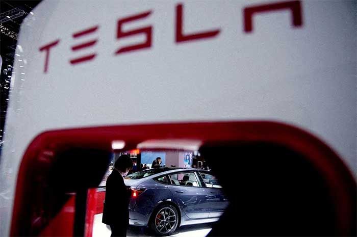 Sebuah kendaraan listrik Tesla terlihat melalui titik pengisian yang ditampilkan selama hari media untuk pameran Auto Shanghai di Shanghai, China 20 April 2021.