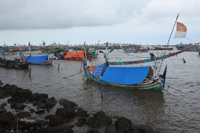 Perahu nelayan ditambatkan akibar gelombang tinggi dan angin kencang di Pelabuhan Panarukan, Situbondo, Jawa Timur, Sabtu (31/12/2022).