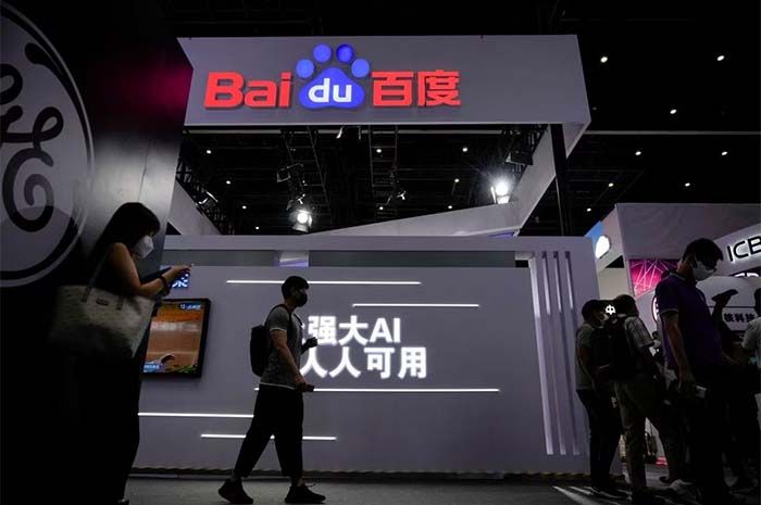 Sejumlah orang berdiri di dekat papan nama Baidu saat Konferensi Kecerdasan Buatan Dunia, menyusul wabah penyakit virus corona (COVID-19), di Shanghai, China, 1 September 2022.