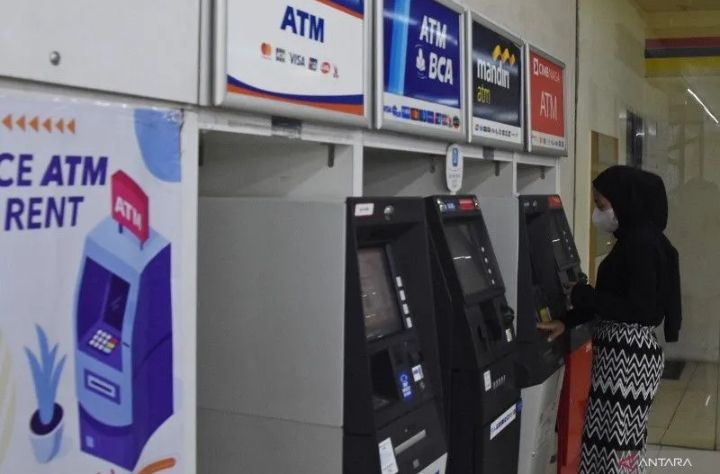Ilustrasi seorang nasabah melakukan transaksi di gerai ATM.