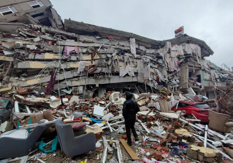 Seorang pria berdiri di tengah reruntuhan gempa di Kahramanmaras Turki Senin 6 Februari 2023