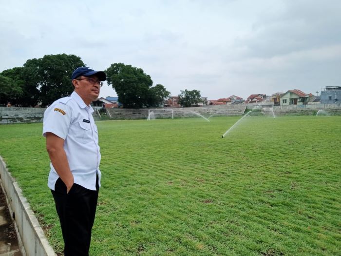 Kadisbudparpora Kota Cimahi, Achmad Nuryana dengan latar springkler yang tengah menyiram rumput lapangan sepakbola di Stadion Sangkuriang yang disebut sekelas Stadion Jatidiri Semarang