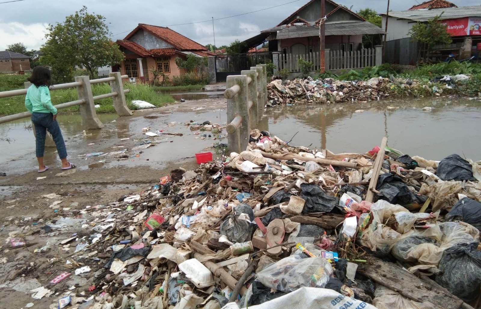 TUMPUKAN sampah di tanggul irigasi sungai Desa Prajawinangun Kulon Kecamatan Kaliwedi Kabupaten Cirebon, Senin (13/2/2023).*