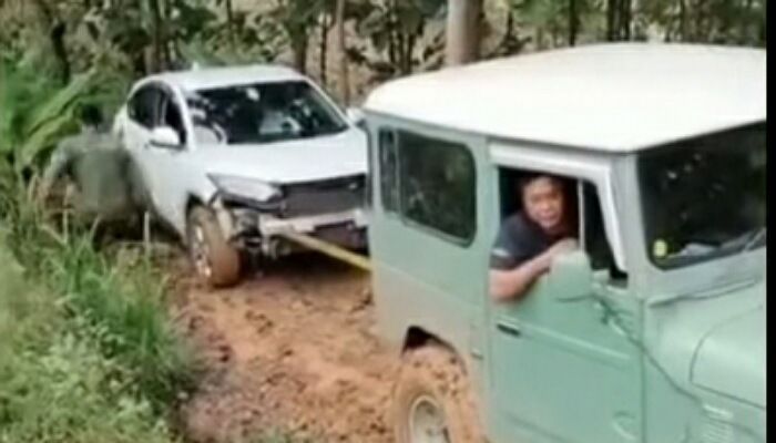  Mobil Honda HRV saat tengah dilakukan evakuasi oleh mobil Jeep setelah  tersesat di hutan Pati 