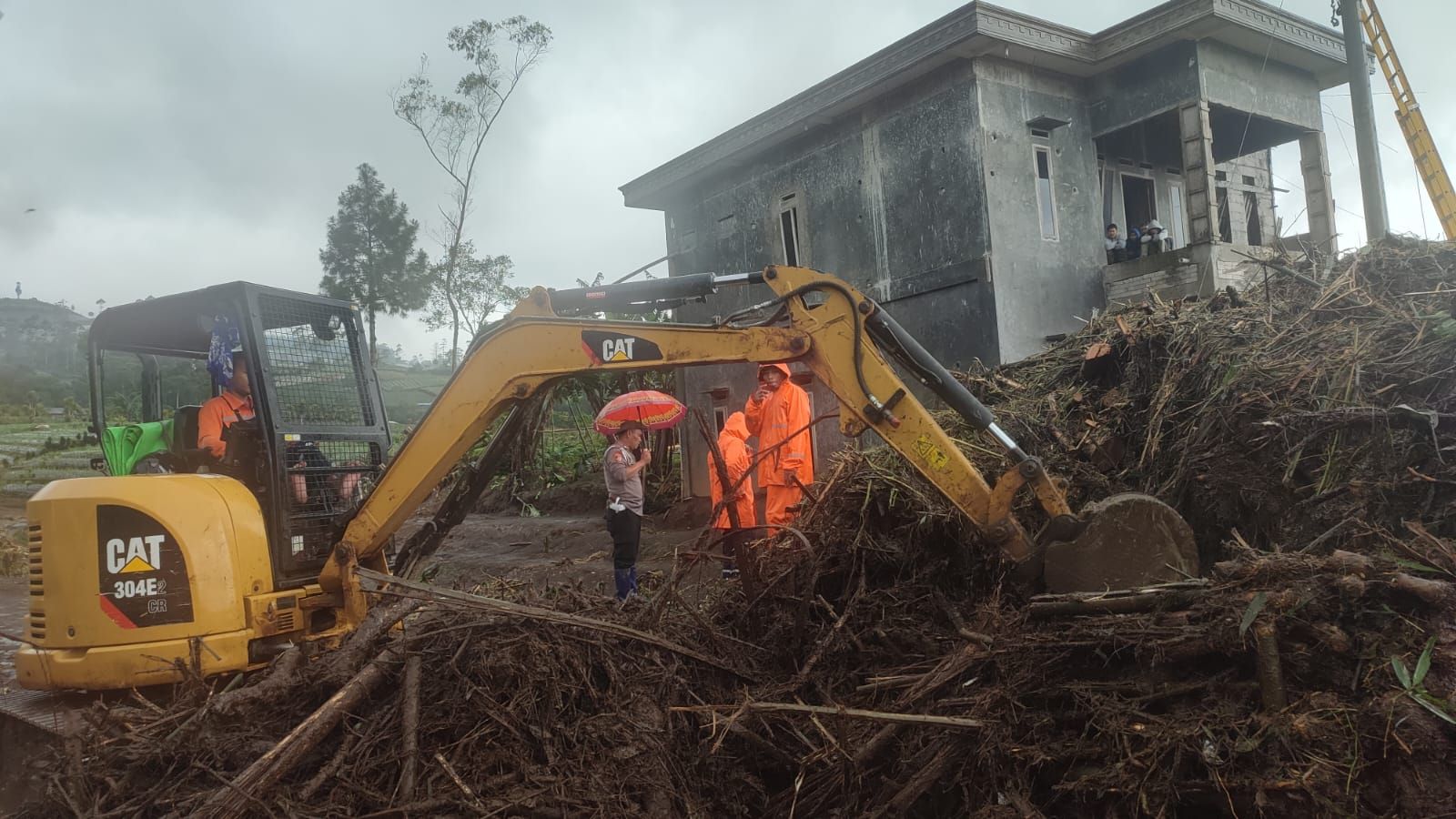 Ekskavator membersihkan material banjir di desa Serang Purbalingga pada 14 Februari 2023.*