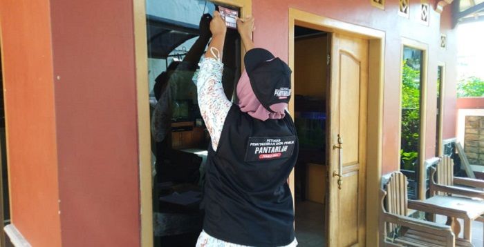 Petugas Pantarlih Kota Tasikmalaya menempelkan stiker di rumah warga.*/kabar-priangan.com/Istimewa