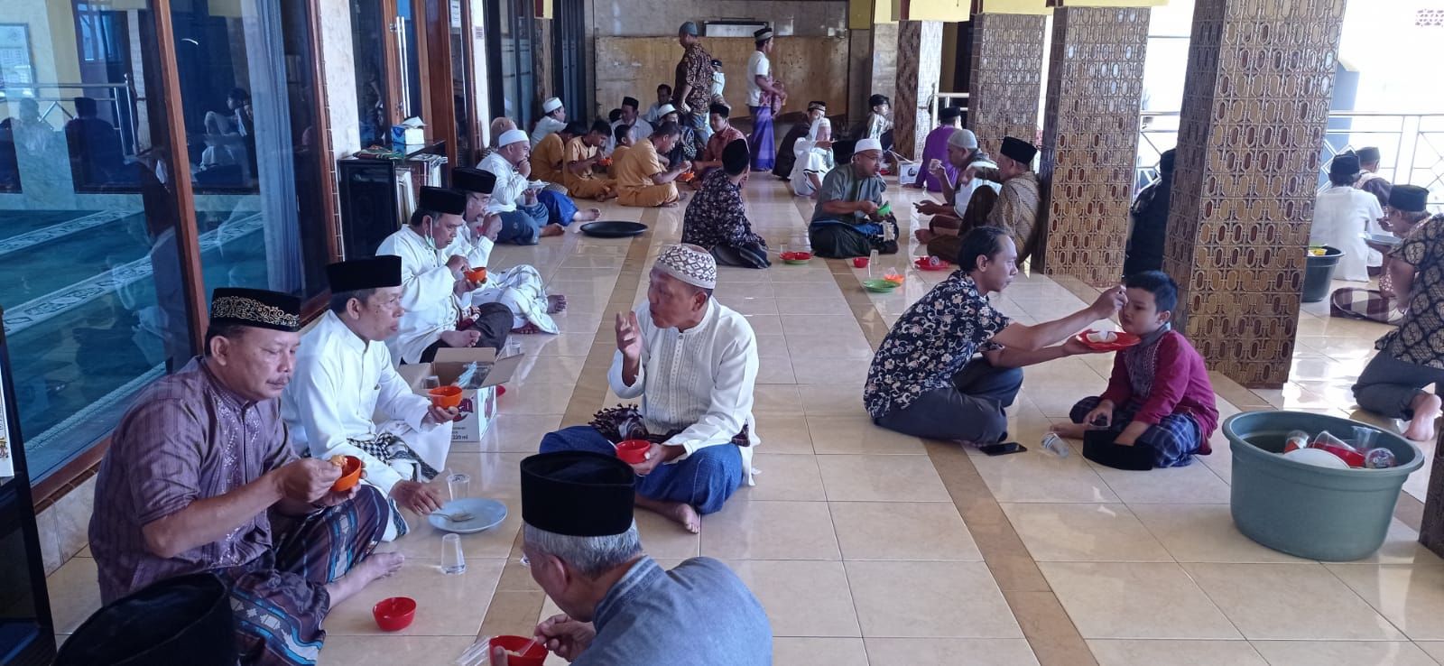 Jamaah Masjid Al Furqon Kebalenan, Banyuwangi menyantap makan siang bersama di teras masjid usai sholat Jumat, 3 Maret 2023.