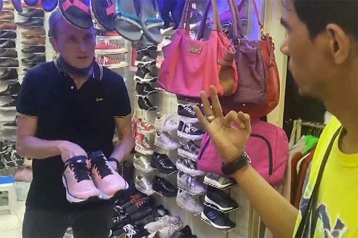 Wartawan Reuters Joe Brock bernegosiasi dengan penjual untuk membeli kembali sepasang sepatu bekas miliknya, setelah melacaknya melalui alat pelacak, di Jakarta, Indonesia, dalam tangkapan layar yang diambil dari sebuah video, 1 November 2022.
