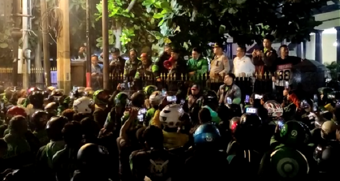 Seorang perwakilan ojol Bandung (pria bertopi dengan menggunakan pengeras suara) menyebut debt collector sudah berada di Polrestabes Bandung dan kasusnya tengah ditangani oleh kepolisian, Selasa 7 Maret 2023.