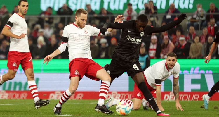 Pemain Eintracht Frankfurt, Randal Kolo Muani saat menghadapi pemain FC Koln, Benno Schmitz di Stadion Rhein Energie pada 12 Februari 2023.  