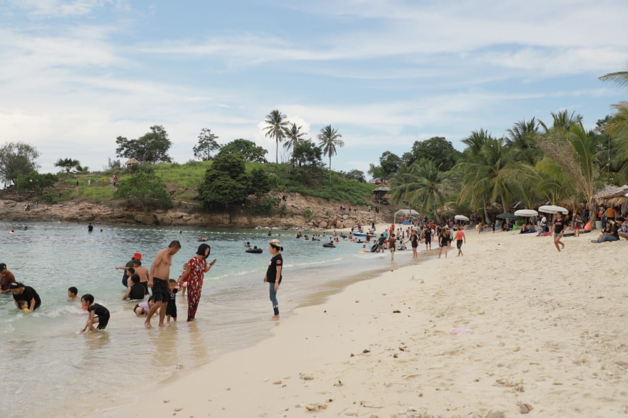 Pengunjung objek wisata Tanjung Cemara Pantai Batu Buaya nampak sedang menikmati liburan bersama keluarga