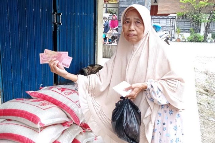 Seorang warga Rangkasbitung, Kabupaten Lebak, menerima sembako dan Rs. 200.000 tunai per Keluarga Penerima Manfaat (KPM) Program Bantuan Pangan (BPNT) yang dilaksanakan oleh Kementerian Sosial. 