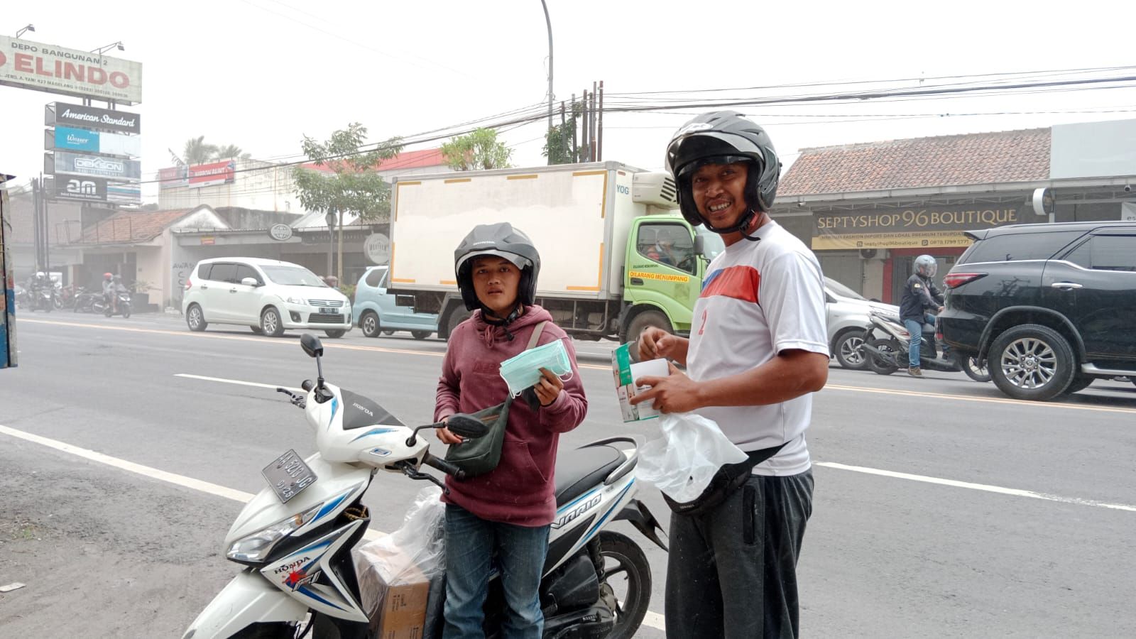 Relawan membagikan masker kepada seorang pengendara sepeda motor yang melintas di Jalan Ahmad Yani Kota Magelang. 