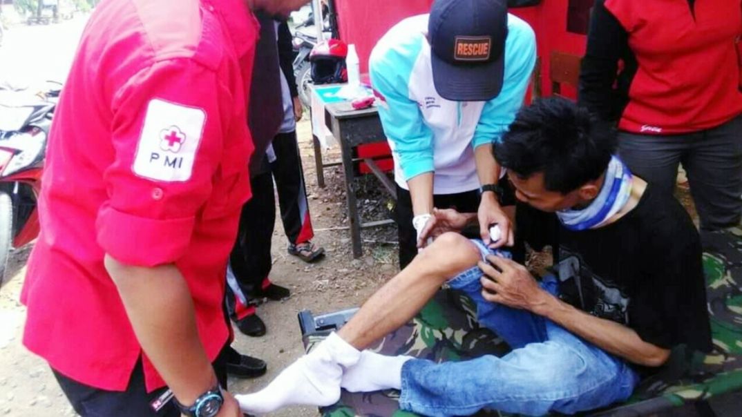 Tim Relawan PMI memberikan perawatan kepada pemudik yang terjatuh
