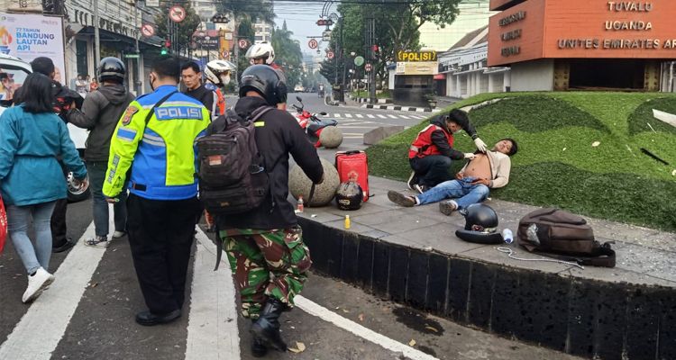 Pengendara motor korban ditabrak angkot di dekat Tugu Simpang Lima Kota Bandung sedang dirawat petugas medis, Minggu 19 Maret 2023