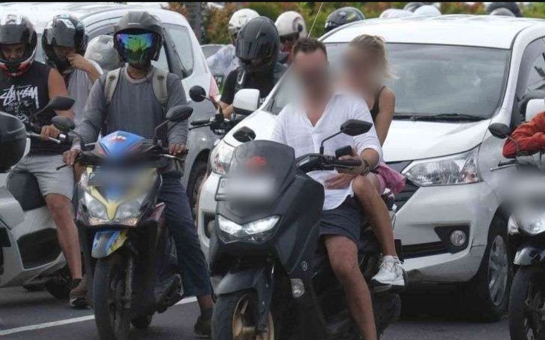 Turis asing mengendarai sepeda motor tanpa mengenakan helm di Jalan Sunset Road, Kuta, Badung, Bali, Selasa (28/2/2023).