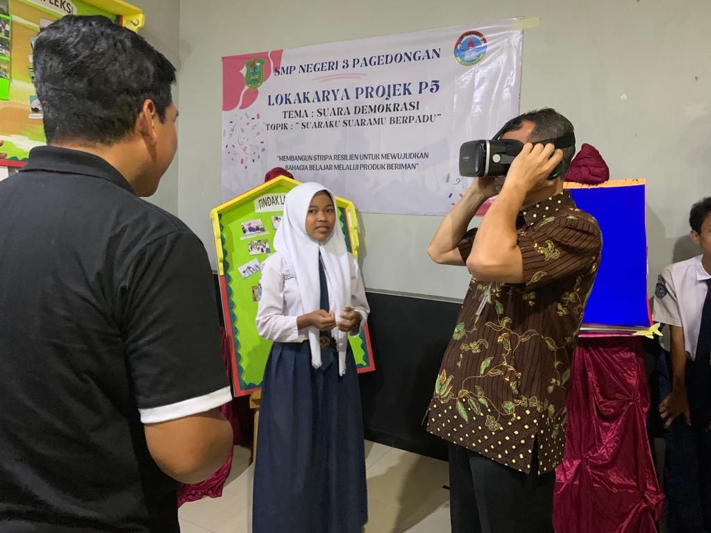 Kepala Dindikpora Banjarnegara Teguh Handoko mencoba alat VR dipandu oleh siswa SMPN 3 Pagedongan belum lama ini