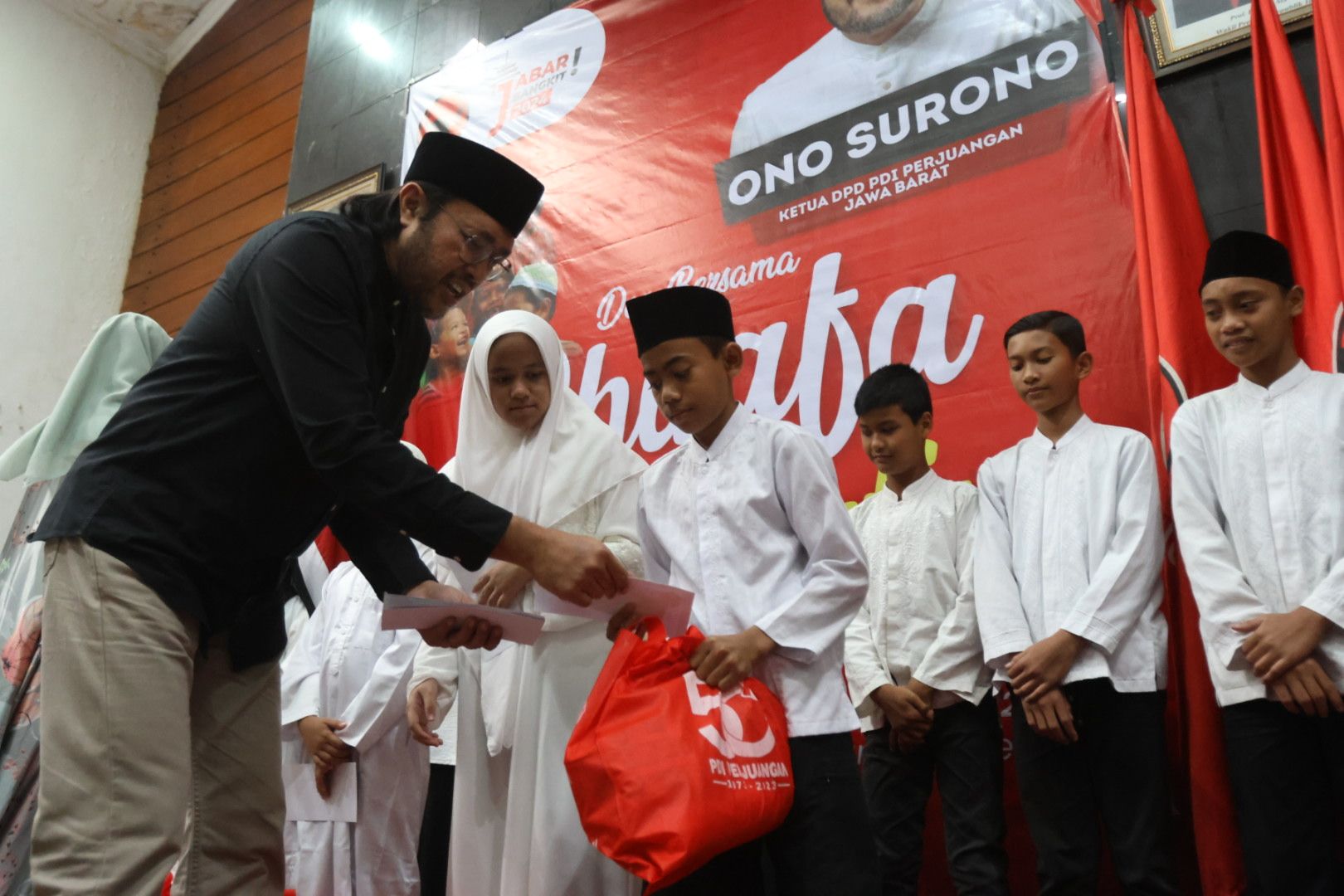 Ketua DPD PDI Perjuangan Jawa Barat Ono Surono menyerahkan bantuan secara simbolis pada acara Doa Bersama Dhuafa dan Anak-anak Yatim, di Kantor DPD PDI Perjuangan Jawa Barat, Bandung, Selasa (21/3/2023). 