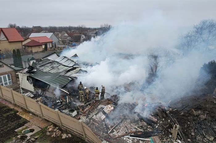 Petugas pemadam kebakaran berusaha memadamkan api di tengah puing-puing rumah yang hancur akibat penembakan baru-baru ini dalam konflik Rusia-Ukraina di kota Khartsyzk di wilayah Donetsk, Ukraina yang dikuasai Rusia, 18 Maret 2023. 