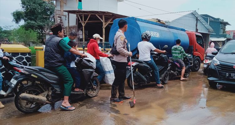 Pembersihan lumpur sisa banjir di Jalan Raya Majalaya - Ibun oleh Kepolisian dari Polsek Ibun