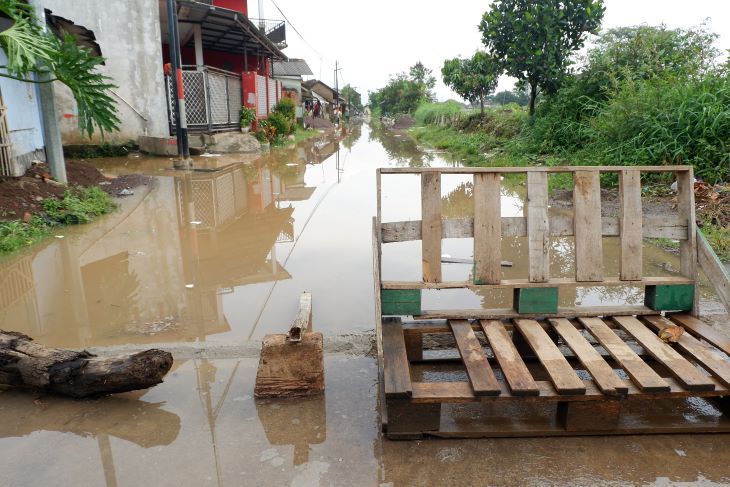 Warga menutup akses jalan Sapan Desa Tegalluar Kecamatan Bojongsoang Kabupaten Bandung akibat air terus meninggi dan dikhawatirkan jatuh korban jiwa yang menimpa pengguna jalan.