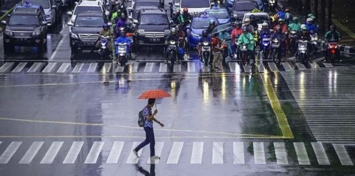 Arsip Foto - Seorang pekerja menggunakan payung untuk menghindari hujan saat menyeberang jalan di kawasan Jalan MH Thamrin, Jakarta. (ANTARA/Aprillio Akbar/hp/aa)