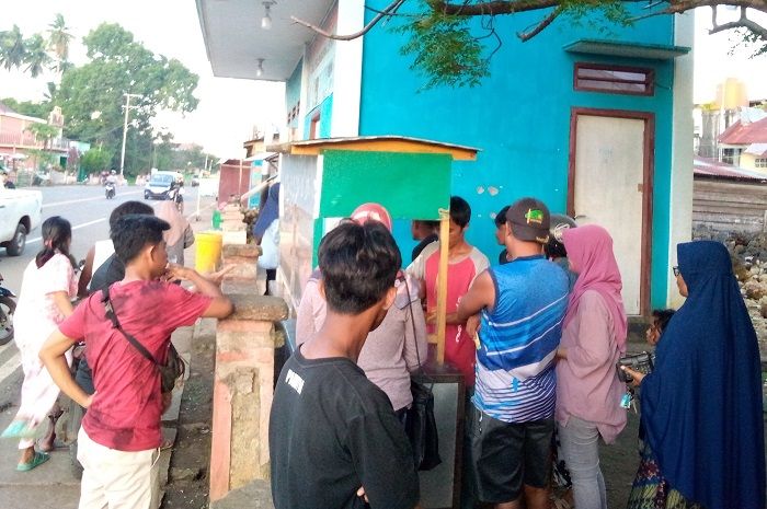 warga mengantri membeli es kelapa muda.