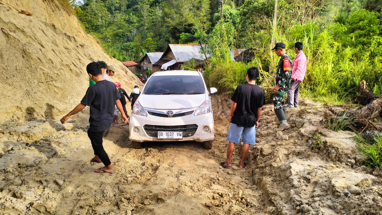 Peronil TNI bersama warga membantu mengevakuasi mobil yang terjebak dalam lumpur. (Foto: Istimewa)