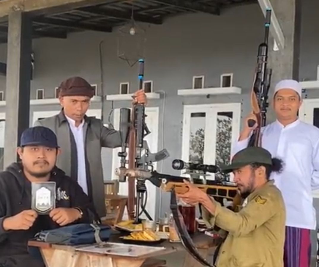 Tangkapan layar video viral oknum pengurus MUI Kabupaten Sukabumi yang memegang senjata laras panjang.