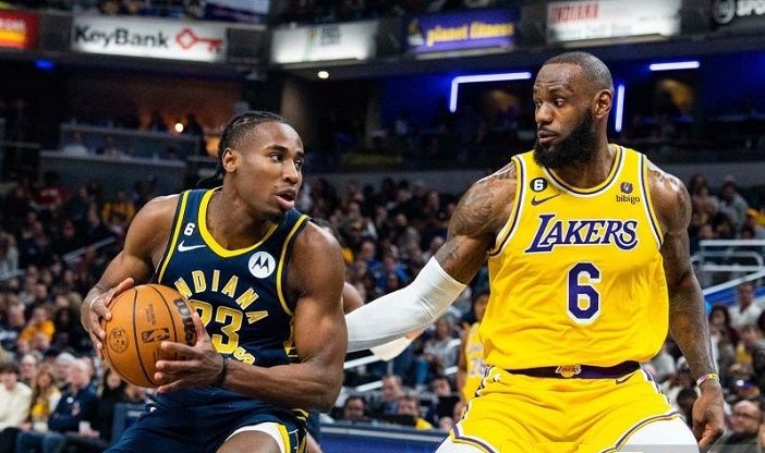 Pemain bola basket Indiana Pacers Aaron Nesmith (23) mengontrol bola saat mengawal pemain bola basket Los Angeles Lakers LeBron James (6) selama pertandingan NBA di Gainbridge Fieldhouse di Indianapolis, Indiana, AS (2 Februari 2023). 