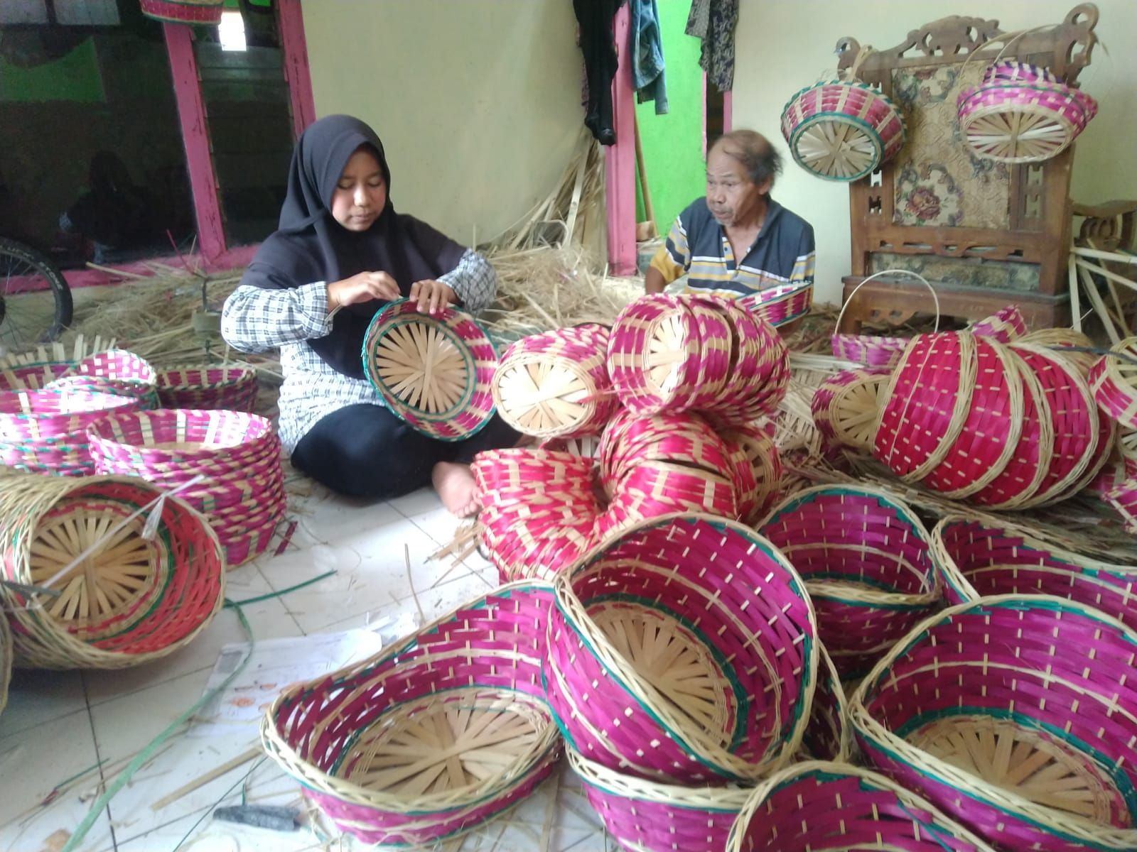 Engkus (64) ditemani anaknya, Mila (35), sedang membuat keranjang parsel di sentra pengrajin bambu Situ Beet, Kelurahan Cipari, Kecamatan Mangkubumi, Kota Tasikmalaya, Rabu 29 Maret 2023.*