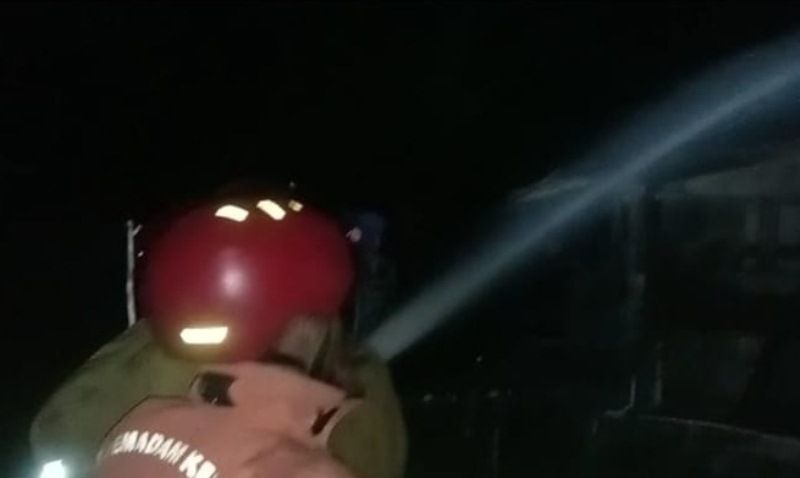 Petugas pemadam kebakaran menyemprotkan air ke kandang sapi yang terbakar di Desa Selo, Kecamatan Tawangharjo, Grobogan, Kamis malam 30 Maret 2023. 