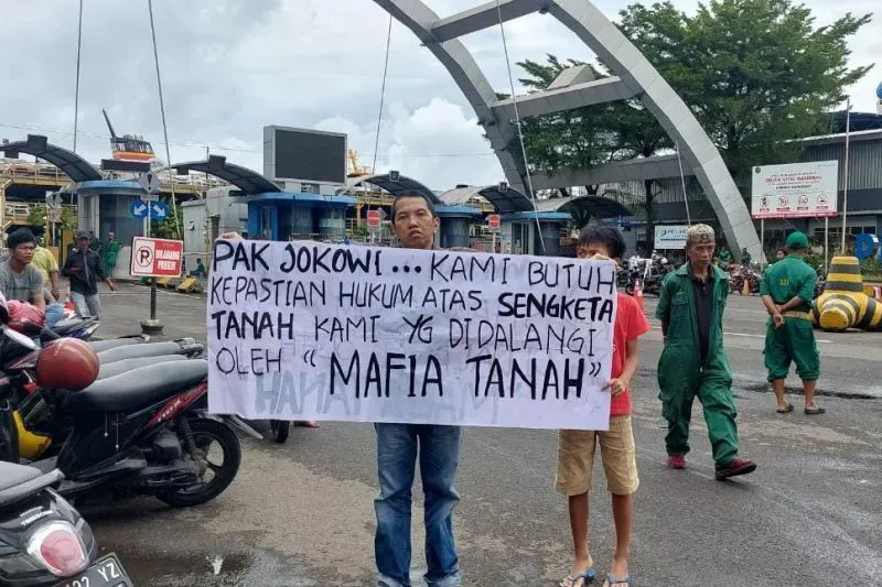 Seorang warga Makassar, Sulsel membentangkan spanduk meminta bantuan ke Presiden Joko Widodo untuk menyelesaikan permasalahan sengketa tanah sejak puluhan tahun di depan Pelabuhan Soekarno-Hatta Makassar.