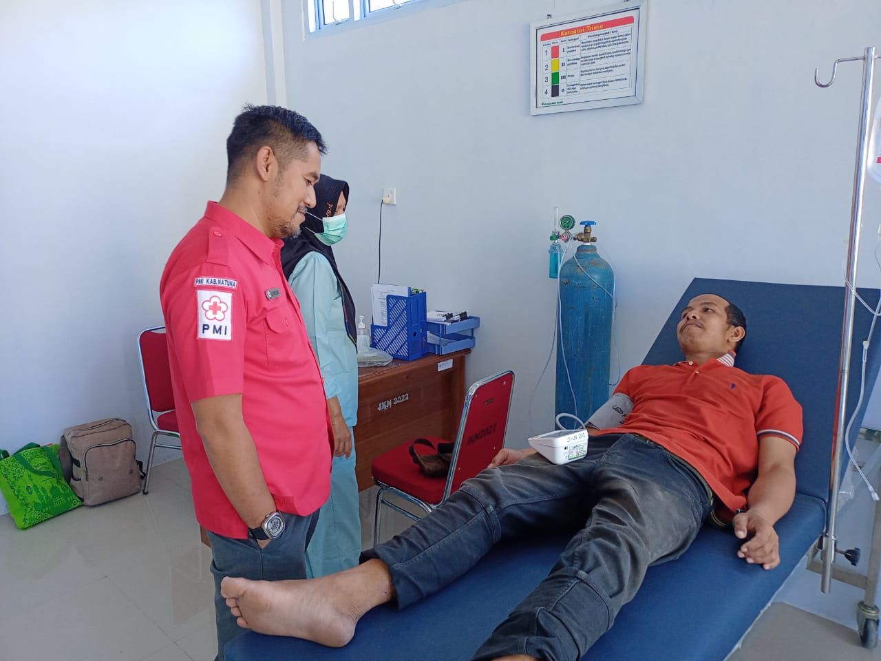 Ketua PMI Natuna, Suhelmi saat menemani Joko memeriksakan kesehatannya di Puskesmas Ranai-f/istimewa 
