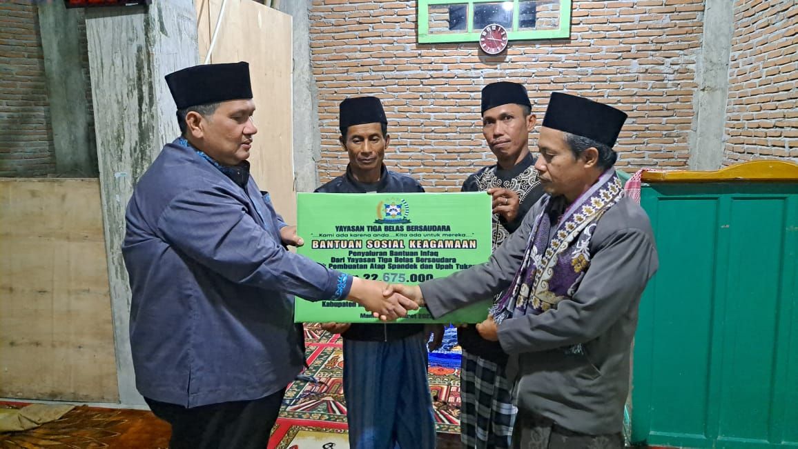 Pembina Yayasan Tiga Bela Bersaudara, H. Musa (kiri) menyerahkan bantuan kepada Panitia Pembangunan Mesjid Nurul Yaqin Lambanan. (Foto: Istimewa)