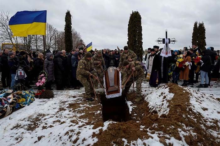 Prajurit Ukraina menurunkan peti mati berisi jenazah saudara seperjuangan mereka Volodymyr Androshchuk, yang baru-baru ini terbunuh dalam pertempuran melawan pasukan Rusia di dekat kota Bakhmut.
