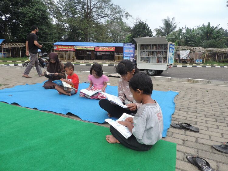 Potret beberapa anak yang sedang membaca buku dari Motor Baca.
