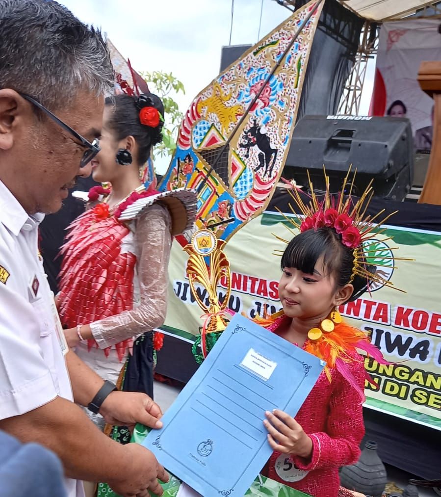 Kepala Dinas Lingkungan Hidup Grobogan, N Agus Prastowo saat memberikan penghargaan kepada Yuwanna Luhtitisari yang menang sebagai juara peragaan busana daur ulang beberapa waktu lalu.
