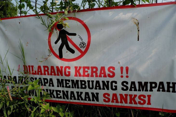 Spanduk peringatan untuk tidak membuang sampah di gerbang Lapang Sansiro Raimbow Jalan Cibodas Raya Kelurahan Antapani Tengah Kecamatan Antapani Kota Bandung, tapi warga tetap membuang sampah di lahan kosong tepat di belakang spanduk.