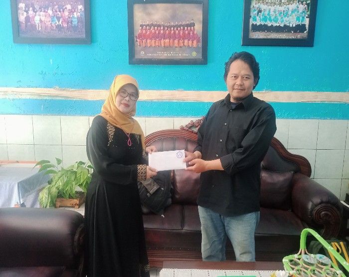 Kepala SDN Baros Mandiri 4 Cimahi menyerahkan donasi untuk program Kado Lebaran untuk korban gempa Cianjur