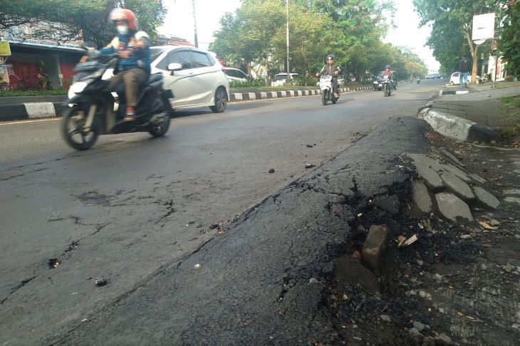 Jalan amblas dan membentuk gundukan dibahu jalan Terusan Jakarta akibat akivitas truk pengangkut tanah urugan.