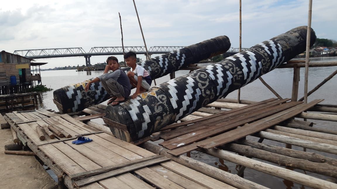 Anak-anak sedang duduk di atas meriam karbit yang terbuat dari kayu. Festival Meriam Karbit Pontianak kembali diadakn 21 April 2023.